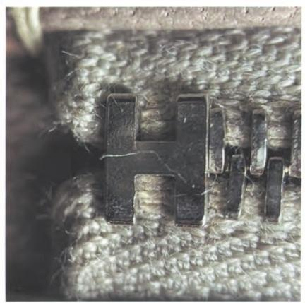 Genuine H zipper pull close-up: raised, rounded edges