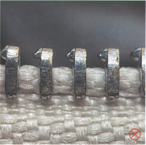 Hermes Kelly Bag Replica-Detail of counterfeit Riri zipper on fake Hermès Kelly bag, featuring irregular teeth and poor finishing.