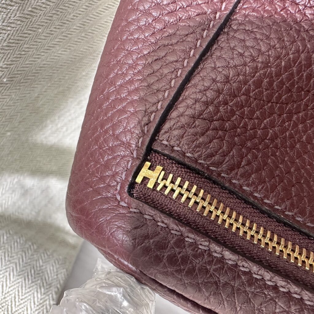 Detailed view of the authentic-style H zipper stop and neat saddle stitching on a Rouge Sellier Hermes Mini Lindy replica.