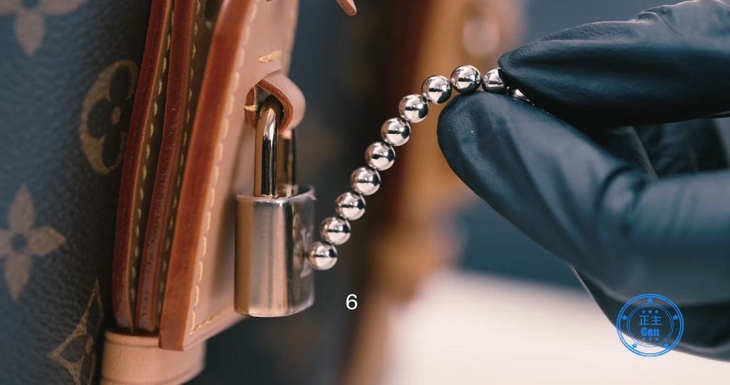 Close-up of Louis Vuitton padlock and strap rivets undergoing magnetic physics testing, demonstrating that both authentic and Piece C share identical extremely weak magnetic pull and complete magnetic resistance in strap components.